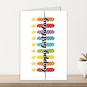 Dettaglio di un biglietto di compleanno con candele colorate e testo di auguri