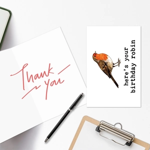 Detail view of animal birthday cards and 'Thank you' card with pens on a desk