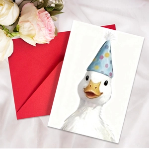Close-up of birthday card with cute duck illustration on white silk with a red envelope