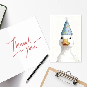 Close-up of cute white duck birthday card with a handwritten Thank You note and pen