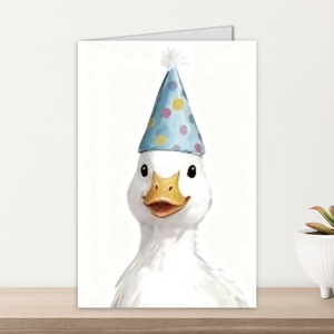Detail of creative birthday card featuring cute duck illustration on wooden shelf