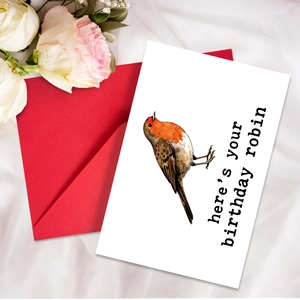 Greeting card with realistic robin bird illustration and bright red envelope on white fabric
