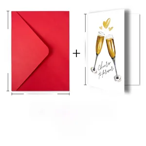 Detailed view of Cheers to Forever wedding card with red envelope and golden heart champagne