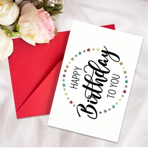 Dettaglio del biglietto di compleanno con stelle colorate e busta rossa su tulle