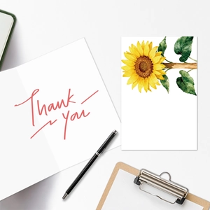 Flat lay van bloemige bedankkaarten met zonnebloemillustratie en een zwarte pen