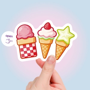 Detail showing hand holding cute cartoon ice cream stickers for DIY scrapbooking