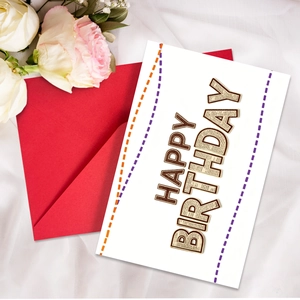 Macro di un biglietto di auguri Happy Birthday con trama di giornale e busta rossa