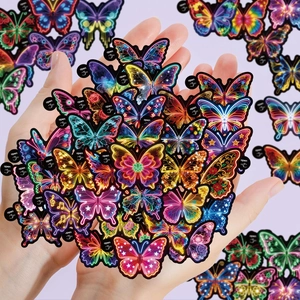 Close-up of vibrant neon butterfly graffiti stickers with easy-tear tabs in hand