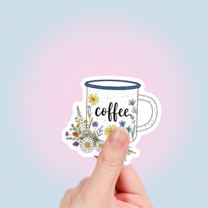 Détail de l'autocollant fleur de café avec main tenant un gobelet émaillé pour journaux