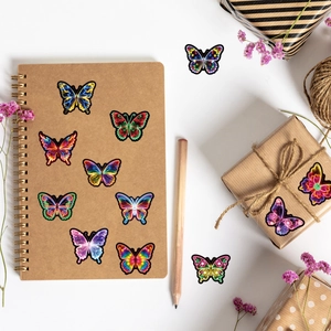 Flat lay of colorful neon butterfly stickers on a notebook for DIY decoration