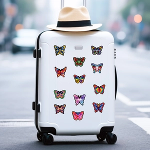 Close-up of 12 colorful neon butterfly stickers on a white travel suitcase