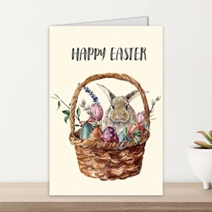 Detalle de tarjeta de Pascua con conejo en acuarela y cesta de flores sobre madera