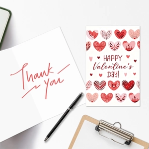 Plano cenital de tarjetas de San Valentín rosas y nota de agradecimiento en escritorio