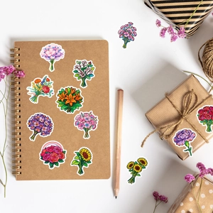 Close-up of vibrant floral bouquet stickers on a notebook with decorative items