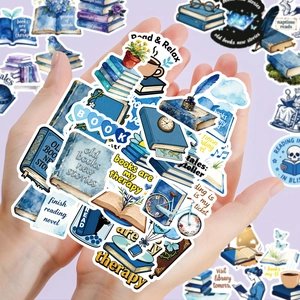 Close-up of hands holding vintage blue reading stickers with book and floral motifs