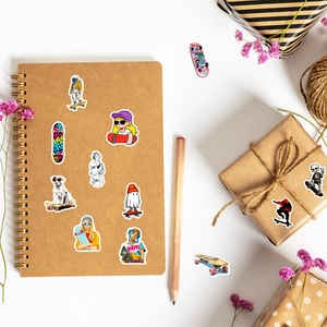 Vue à plat d'autocollants de skateboard sur carnet en kraft avec crayon et fleurs séchées