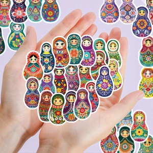 Close-up of colorful Russian Matryoshka doll stickers held in hands for decoration