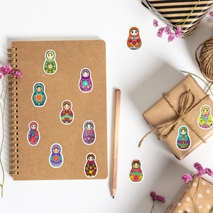 Detailed flat lay of colorful Matryoshka stickers on notebook and gift box packaging