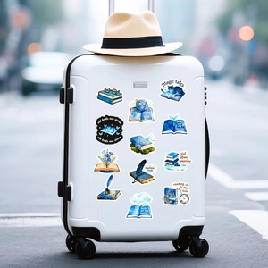 Blue watercolor book stickers on a white suitcase in an outdoor setting