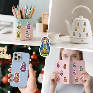 Waterproof Russian nesting doll stickers applied on a phone case, notebook, and kettle