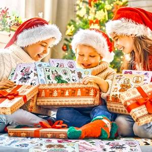 Bambini con cappelli di Babbo Natale giocano con adesivi colorati per ragazze dei cartoni
