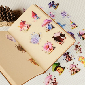 Close-up of fairy mushroom house PET stickers on a vintage journal with warm decor