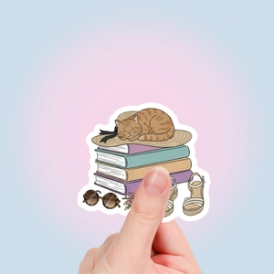 Detalle de pegatina con gato durmiendo sobre libros y elementos de verano