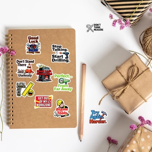 Flat lay of creative construction themed vinyl stickers on a notebook with dry flowers