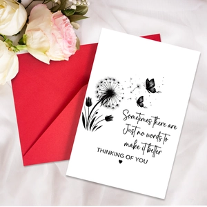 Detail of sympathy card with dandelion pattern, red envelope and white rose setting