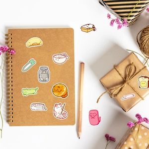 Detail of cute cat stickers on a notebook with decorative dried flowers and pencils