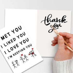 Close-up of a folding anniversary card with romantic stick figure illustrations