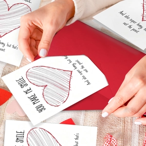 Valentine's Day card with red heart and envelope on warm knit background