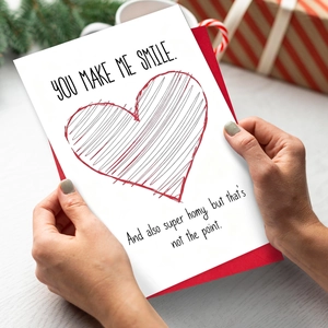 Valentine card with red envelope and heart design held against a festive background