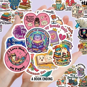 Close-up of pink bookworm stickers featuring cartoon cats and reading quotes on hand