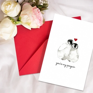 Romantic greeting card with penguins and heart on white silk background with roses