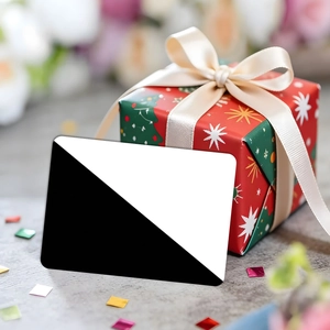 Detail of red Christmas gift box with white silk ribbon and geometric patterned greeting card
