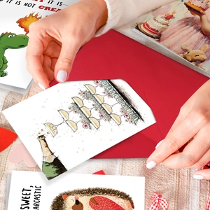 Artistic illustrated wedding greeting cards with red envelope on a textured fabric