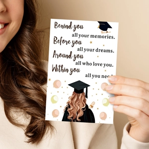 Close-up of a hand holding an inspirational graduation greeting card with artistic text
