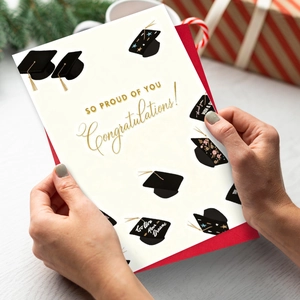 Detail of graduation greeting card with gold foil text and a premium red envelope