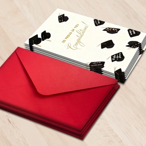 Detailed stack of graduation cards with Congratulations text and red envelopes on wood