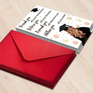 Macro view of graduation greeting cards with red envelopes on a light wooden background