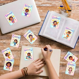 Dettaglio di carte motivazionali per bambini posizionate su laptop e un libro