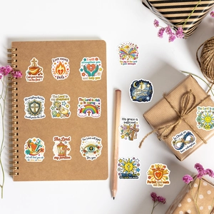 Bible verse stickers with cross and heart designs on a brown notebook and gift box