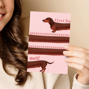 Pink dachshund greeting card with I Love You text being held by a smiling person