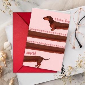 Macro shot of a long dachshund greeting card with a red envelope on a cozy desk setup