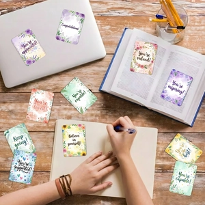 Set of 18 watercolor floral motivational cards with positive quotes on a desk setting