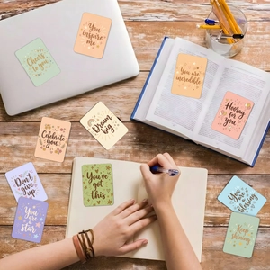 Macro detail of positive quote cards in pastel colors on a rustic wooden desk workspace