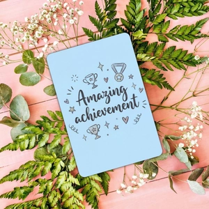 Close-up of Amazing Achievement card with hand-drawn trophy on pink wood background