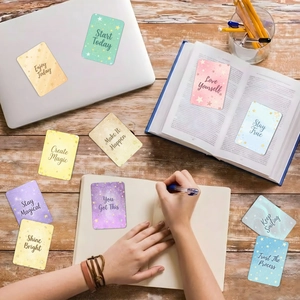 Gros plan de cartes de motivation colorées avec paillettes dorées et citations sur laptop