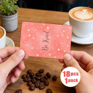 Gros plan d'une main tenant une carte Be Kind avec étoiles dorées sur fond pastel